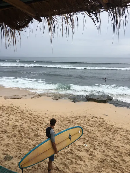 Tim carrying a longboard down to a point break